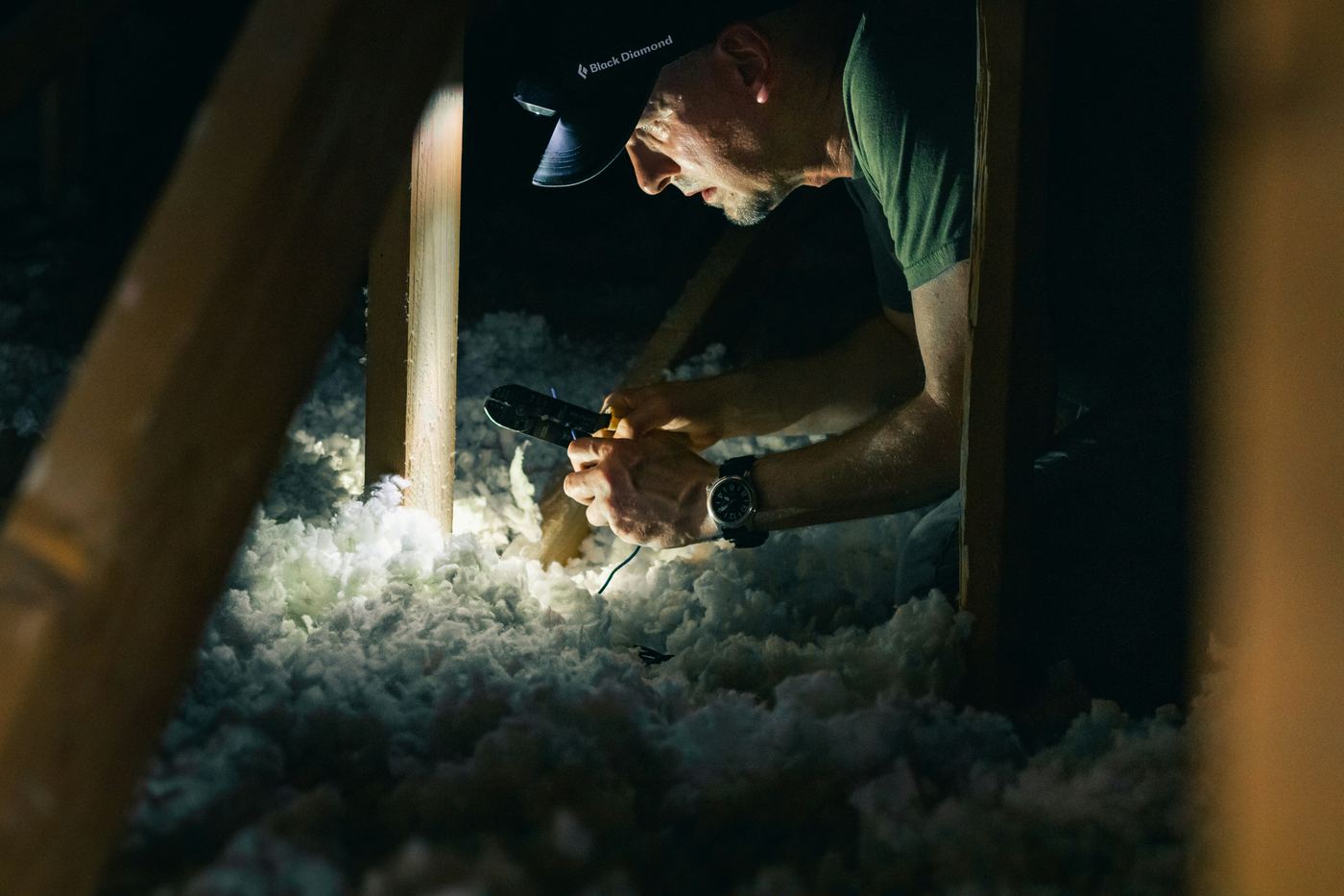 Installer checking blown-in insulation depth in an attic