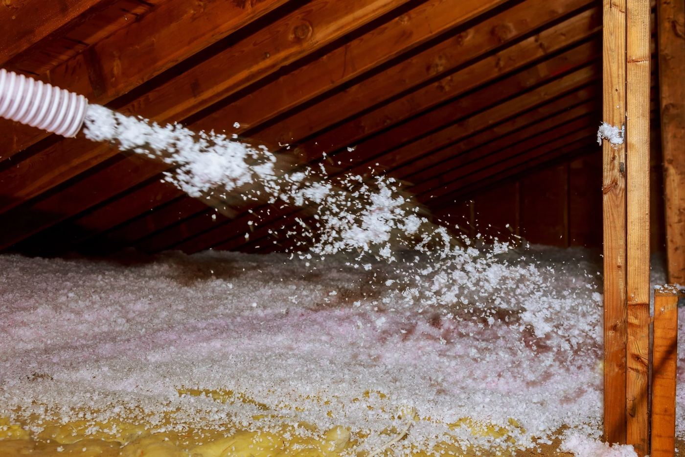Hose distributing blown-in insulation across an attic floor