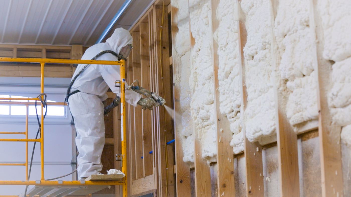 Crew on scaffolding spraying foam insulation in a commercial building